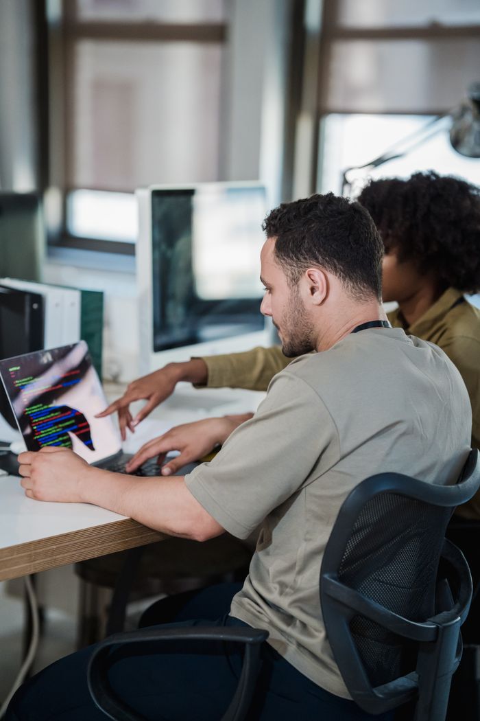 why-choose-us A diverse team collaborating on coding in a modern office environment.