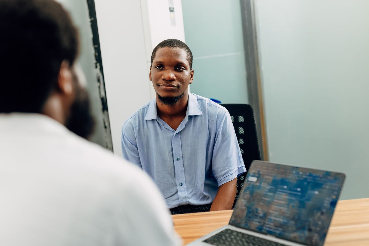about-01 A business meeting in a modern office in Lagos, Nigeria featuring two professionals engaged in a discussion.
