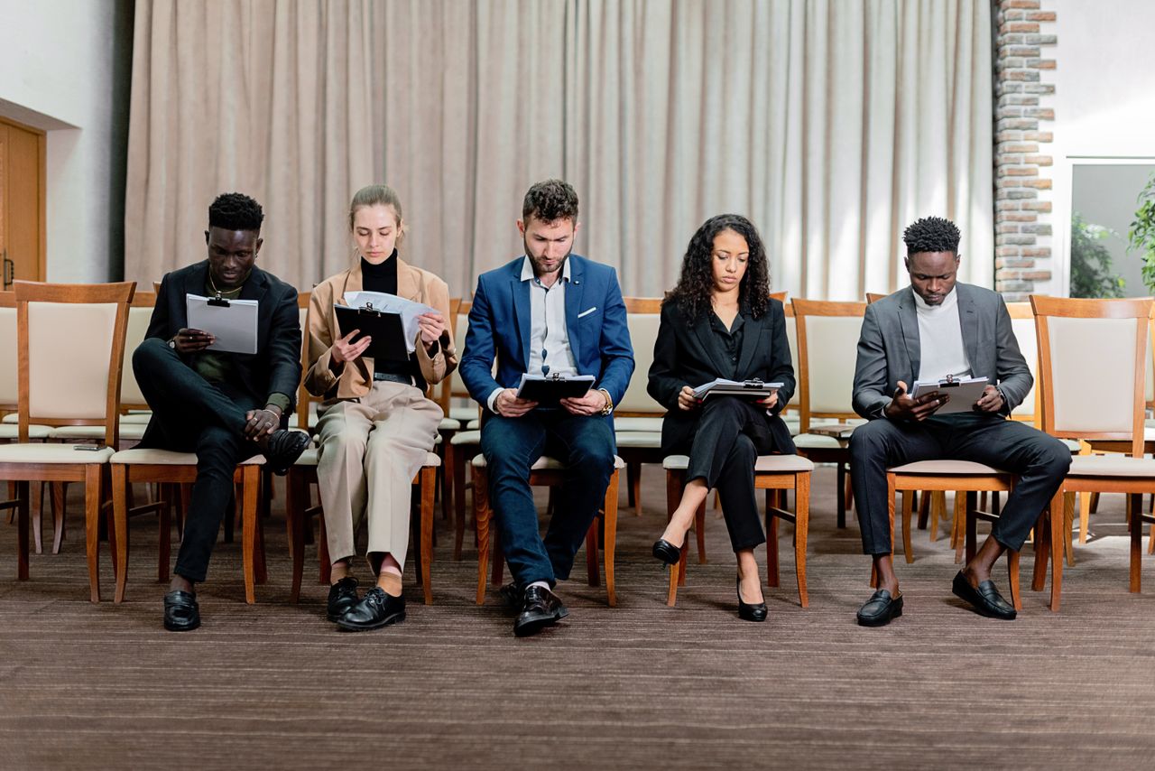 services-01 A diverse group of professionals attentively reviewing documents indoors.